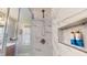 Beautiful shower with marble tile surround, shower niche and frameless glass door at 717 Washington Ct, Anderson, IN 46011
