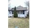 Home exterior featuring neutral siding, complementing a mature evergreen tree in the front yard at 834 N Temple Ave, Indianapolis, IN 46201