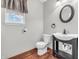 Cozy half bathroom with black basin sink, decorative mirror, toilet, and a window at 878 Hollowood Ln, Avon, IN 46123