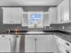 Bright kitchen featuring stainless steel dishwasher, sink, white cabinets and dark countertops at 878 Hollowood Ln, Avon, IN 46123