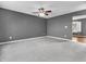 Spacious carpeted living room showcasing a ceiling fan, fresh paint, and a view to the next room at 878 Hollowood Ln, Avon, IN 46123
