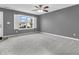 A carpeted living room features a ceiling fan, a window with shutters, and freshly painted walls at 878 Hollowood Ln, Avon, IN 46123