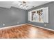 Bright living room featuring hardwood floors, modern lighting and a large window with charming white shutters at 878 Hollowood Ln, Avon, IN 46123