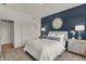 Cozy bedroom highlighted by navy accent wall, white bedding, and decorative mirror at 8931 Alexander Ridge Dr, McCordsville, IN 46055