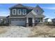 Two-story home featuring an attached garage, green siding and charming architectural details against a clear blue sky at 8931 Alexander Ridge Dr, McCordsville, IN 46055