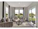 Bright sitting area with large windows, comfortable seating, neutral colors, and an exterior view of the lake at 8931 Alexander Ridge Dr, McCordsville, IN 46055