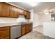 Modern kitchen featuring wood cabinets, neutral countertops, and stainless steel dishwasher at 9820 Legends Creek Dr # 103, Indianapolis, IN 46229