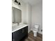Elegant bathroom showcases a dark vanity with gold hardware and white countertop next to the toilet at 124 1St. Se Ave, Carmel, IN 46032