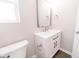 Bathroom featuring a white vanity with modern fixtures, a framed mirror, and a toilet at 1305 W 23Rd St, Indianapolis, IN 46208