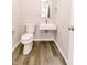 Modern powder room with a sleek floating sink, contemporary mirror, and wood-look flooring at 1305 W 23Rd St, Indianapolis, IN 46208