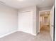 A light-filled bedroom features neutral walls, plush carpet and a large double door closet at 1305 W 23Rd St, Indianapolis, IN 46208