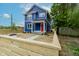 New blue construction with white trim and a red front door protected by a wooden fence at 1305 W 23Rd St, Indianapolis, IN 46208