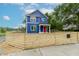 Blue home with a red door is surrounded by a wooden fence at 1305 W 23Rd St, Indianapolis, IN 46208