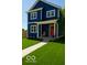 Charming two-story home featuring a blue exterior with a red front door and well-manicured lawn at 1305 W 23Rd St, Indianapolis, IN 46208