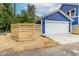 Side view of a blue home featuring a white garage door and wooden fence at 1305 W 23Rd St, Indianapolis, IN 46208