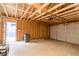 Unfinished garage featuring exposed wood framing, a garage door, and a door leading outside at 1305 W 23Rd St, Indianapolis, IN 46208
