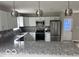 Well-lit kitchen with white cabinets, gray granite countertops, and stainless steel appliances at 1305 W 23Rd St, Indianapolis, IN 46208