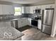 Bright modern kitchen featuring gray granite countertops, white cabinets, and stainless steel appliances at 1305 W 23Rd St, Indianapolis, IN 46208