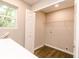 Bright laundry room with wood floors, shelving, window, and hookups for washer and dryer at 1305 W 23Rd St, Indianapolis, IN 46208