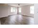 Bright living room with hardwood floors, a ceiling fan, and large windows at 1305 W 23Rd St, Indianapolis, IN 46208