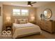 Serene main bedroom with neutral decor, featuring large windows and a stylish round mirror at 1305 W 23Rd St, Indianapolis, IN 46208