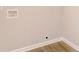 Close-up of a beige wall showing floor trim, an electrical outlet, and water hookups at 1305 W 23Rd St, Indianapolis, IN 46208