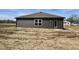 Side view of new construction home with dark siding and level backyard at 1704 N Winthrop Rd, Muncie, IN 47304