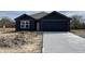 New construction with dark siding, concrete driveway, and attached two car garage at 1704 N Winthrop Rd, Muncie, IN 47304