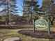 Welcome to The Knoll community sign with manicured lawn and mature trees creates a warm inviting atmosphere at 2207 Rome Dr # B, Indianapolis, IN 46228