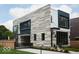 Eye-catching home featuring stone and siding, paired with black frame windows, and gated driveway at 2719 Carrollton Ave, Indianapolis, IN 46205