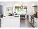Modern kitchen with white cabinets, quartz countertops, stainless appliances, and breakfast nook area at 2719 Carrollton Ave, Indianapolis, IN 46205