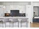 Bright kitchen featuring white cabinets, black backsplash, stainless steel appliances, and island seating at 2719 Carrollton Ave, Indianapolis, IN 46205