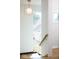 Modern staircase with wooden handrail, contemporary lighting fixture, and bright white walls at 2719 Carrollton Ave, Indianapolis, IN 46205