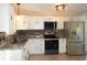 Cozy kitchen featuring stainless steel appliances, white cabinets, and laminate countertops at 2847 Merts Dr, Indianapolis, IN 46237