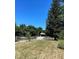 Scenic view of the property featuring sprawling lawn, tall trees, and a winding driveway at 2847 Merts Dr, Indianapolis, IN 46237