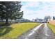 Well-maintained yard with healthy green grass, a large tree, and a gravel driveway leading to the home at 2847 Merts Dr, Indianapolis, IN 46237