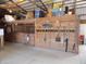 Horse barn interior with stalls along the side. Rakes and shovels hang on the stall wall at 3060 N Alaska Rd, Cloverdale, IN 46120