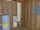 Utility room with a water heater and a gray electrical panel box mounted to the insulated stud wall at 3060 N Alaska Rd, Cloverdale, IN 46120