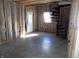 An unfinished basement showing a doorway leading outside and a black spiral staircase at 3060 N Alaska Rd, Cloverdale, IN 46120