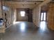 Unfinished basement showcasing a spiral staircase and a doorway leading to the outside at 3060 N Alaska Rd, Cloverdale, IN 46120