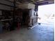 Spacious garage view with concrete floor, tools, shelving, and storage with a view to the outside at 3060 N Alaska Rd, Cloverdale, IN 46120