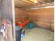 View of inside the horse stall in the barn with hay on the ground and an orange wheelbarrow at 3060 N Alaska Rd, Cloverdale, IN 46120