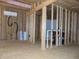Unfinished room showing wall studs, insulation, water heater, HVAC, and electrical components at 3060 N Alaska Rd, Cloverdale, IN 46120