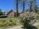 Brick home with landscaped yard featuring a variety of trees, flowers and manicured shrubs and black asphalt driveway at 3370 Walnut Creek Ct, Carmel, IN 46032