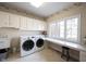Functional laundry room with washer, dryer, counter space, and storage cabinets at 3370 Walnut Creek Ct, Carmel, IN 46032