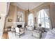 Elegant living room with fireplace, large windows, and high ceilings, and ornate chandelier at 3370 Walnut Creek Ct, Carmel, IN 46032