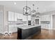 Well-lit kitchen with a large island, white cabinets, stainless steel appliances, and modern pendant lighting at 4248 Stone Lake Dr, Zionsville, IN 46077