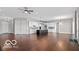 Spacious living room with hardwood floors, white walls, and a modern kitchen island in the background at 4248 Stone Lake Dr, Zionsville, IN 46077