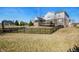 Spacious backyard with black metal fence, basketball court, deck and mature trees on a sunny day at 4431 Hickory Stick Row, Greenwood, IN 46143