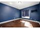 Bedroom with hardwood floors, blue walls, and a window with a shade at 4431 Hickory Stick Row, Greenwood, IN 46143